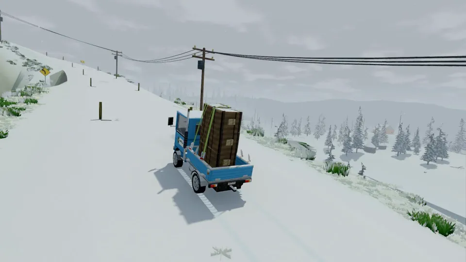 A loaded truck climbing a snowy mountain road beside power lines.