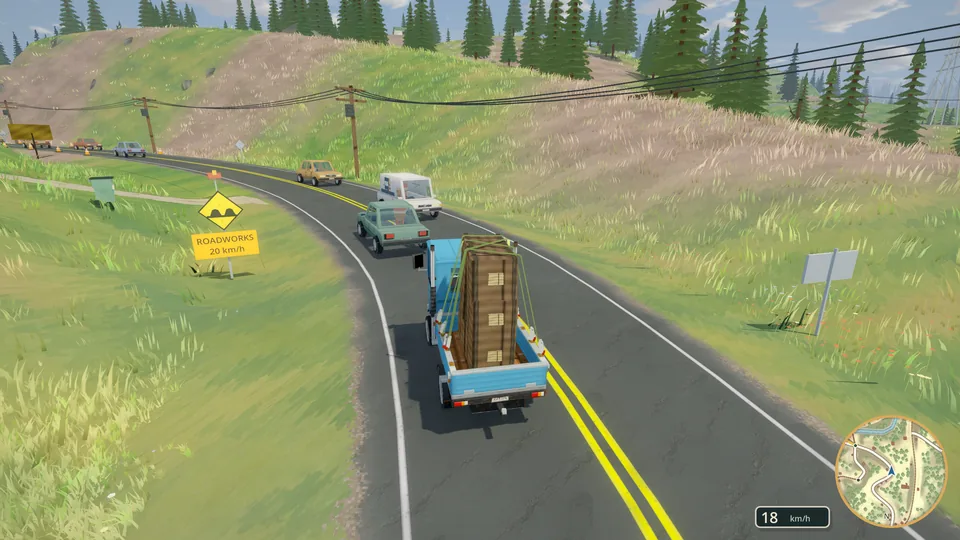A loaded blue truck climbing a mountain road past a roadside flag.