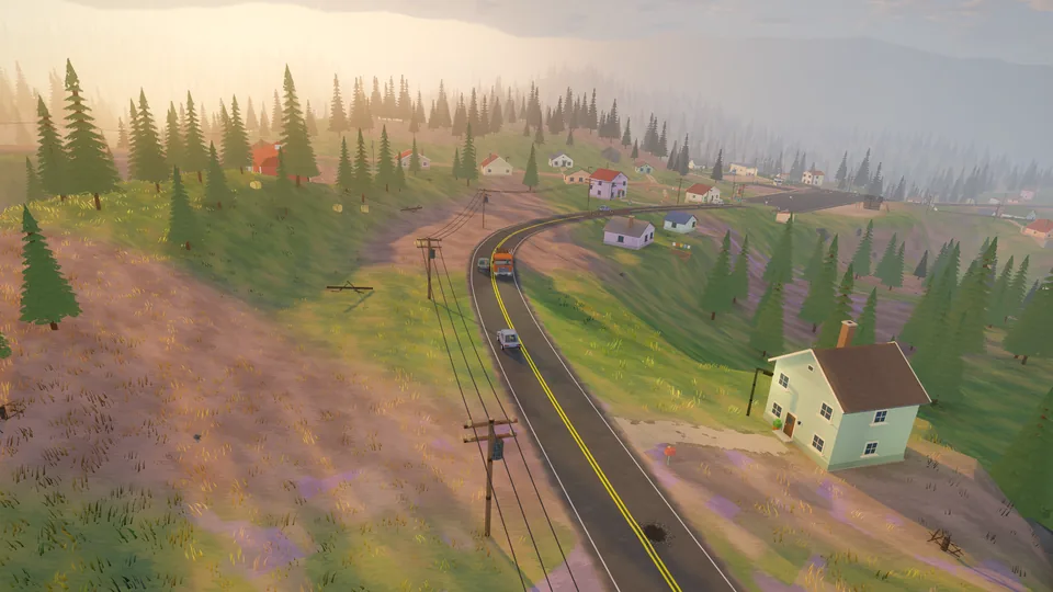 Aerial view of a dirt road winding through forest at dusk.