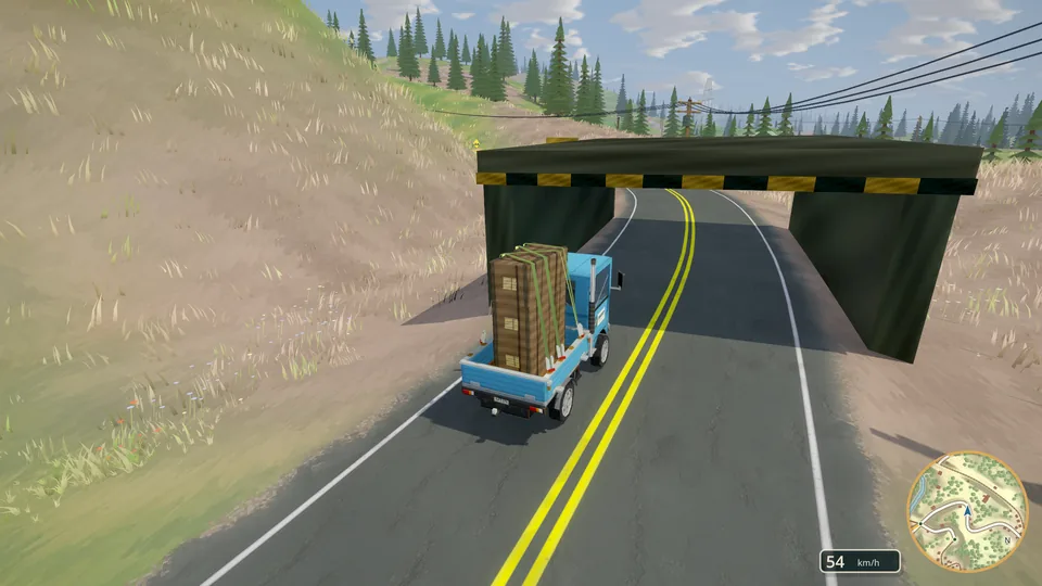 A loaded truck passing beneath a railway overpass on a mountain highway.